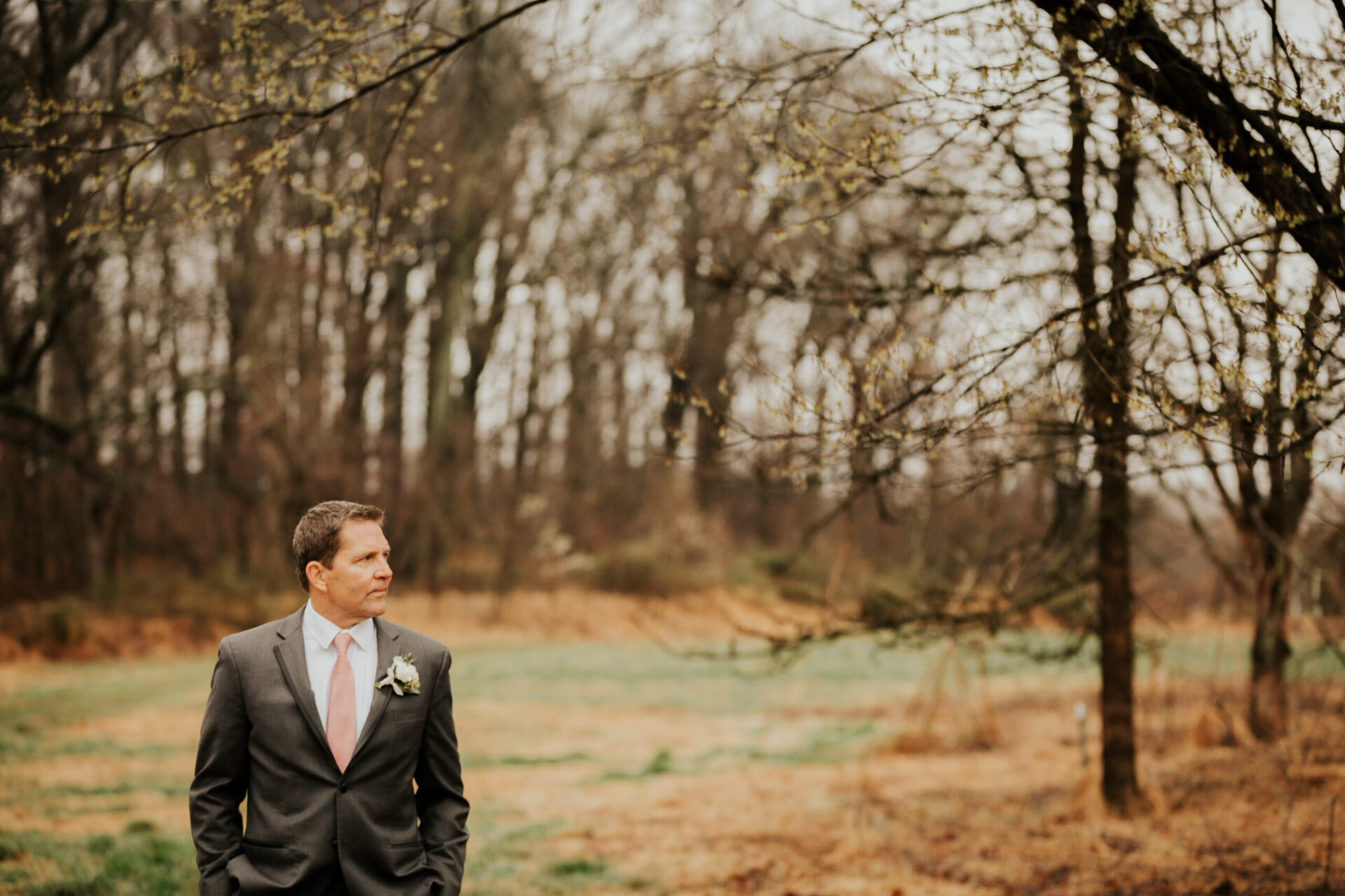 Zion Springs Real Wedding groom walking through the natural fields and woods