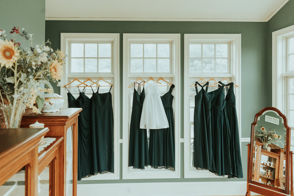 Exquisite bride and bridesmaids dresses hanging and ready for a wedding at Zion Springs, a popular all-inclusive wedding venue in Northern Virginia.