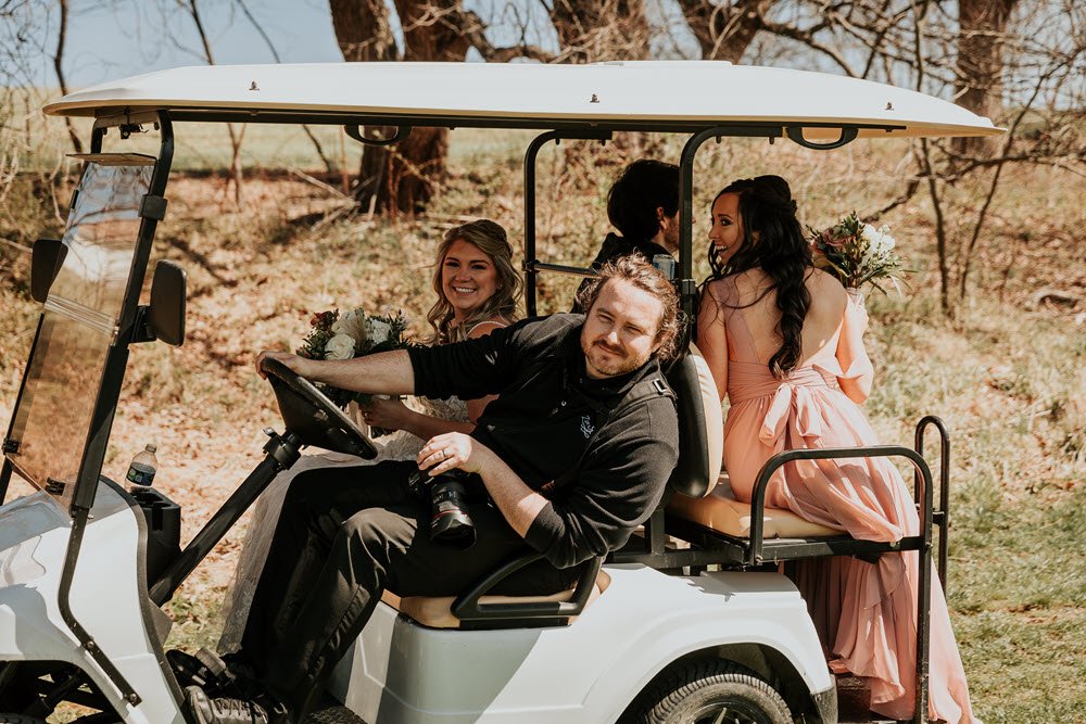 Bride and bridesmaids in a golf cart heading to Zion Springs' most picturesque spots for a photo op, popular for outdoor weddings in Northern Virginia.