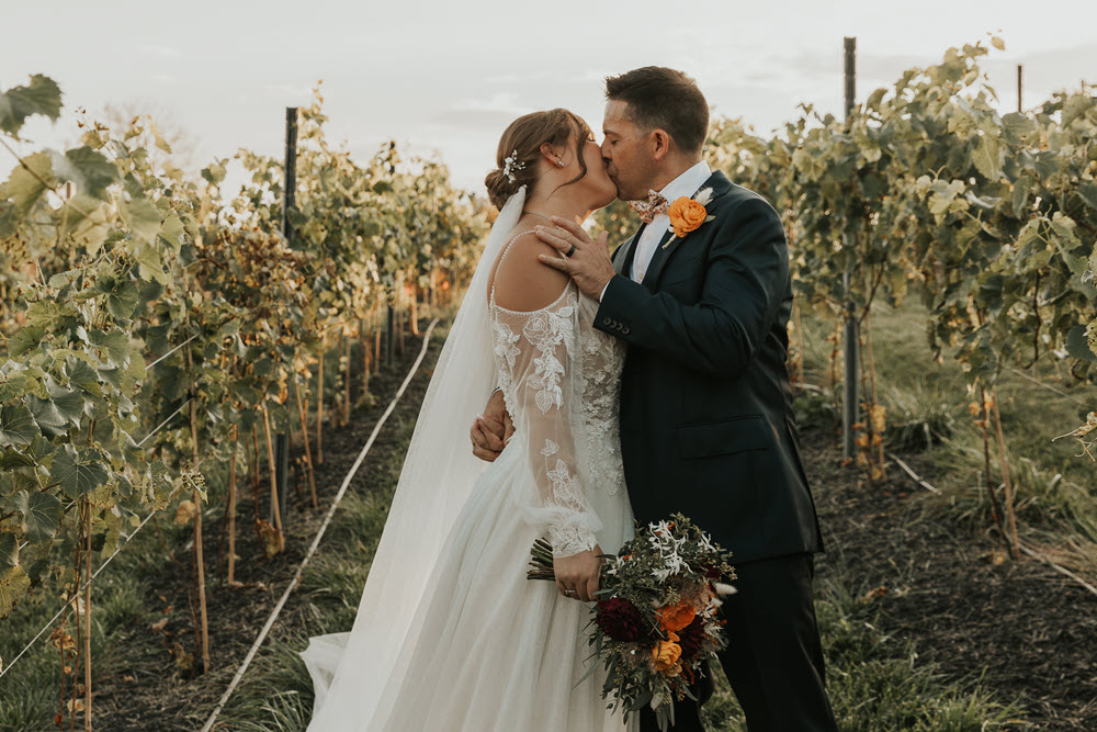Newlyweds sharing a romantic moment in the vineyard at Zion Springs, a barn wedding venue in Northern Virginia.