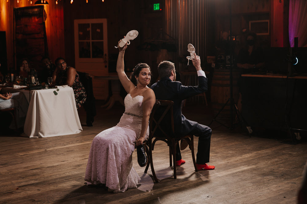 Newlyweds play the wedding shoe game at their Zion Springs reception, a barn wedding venue in Northern Virginia.